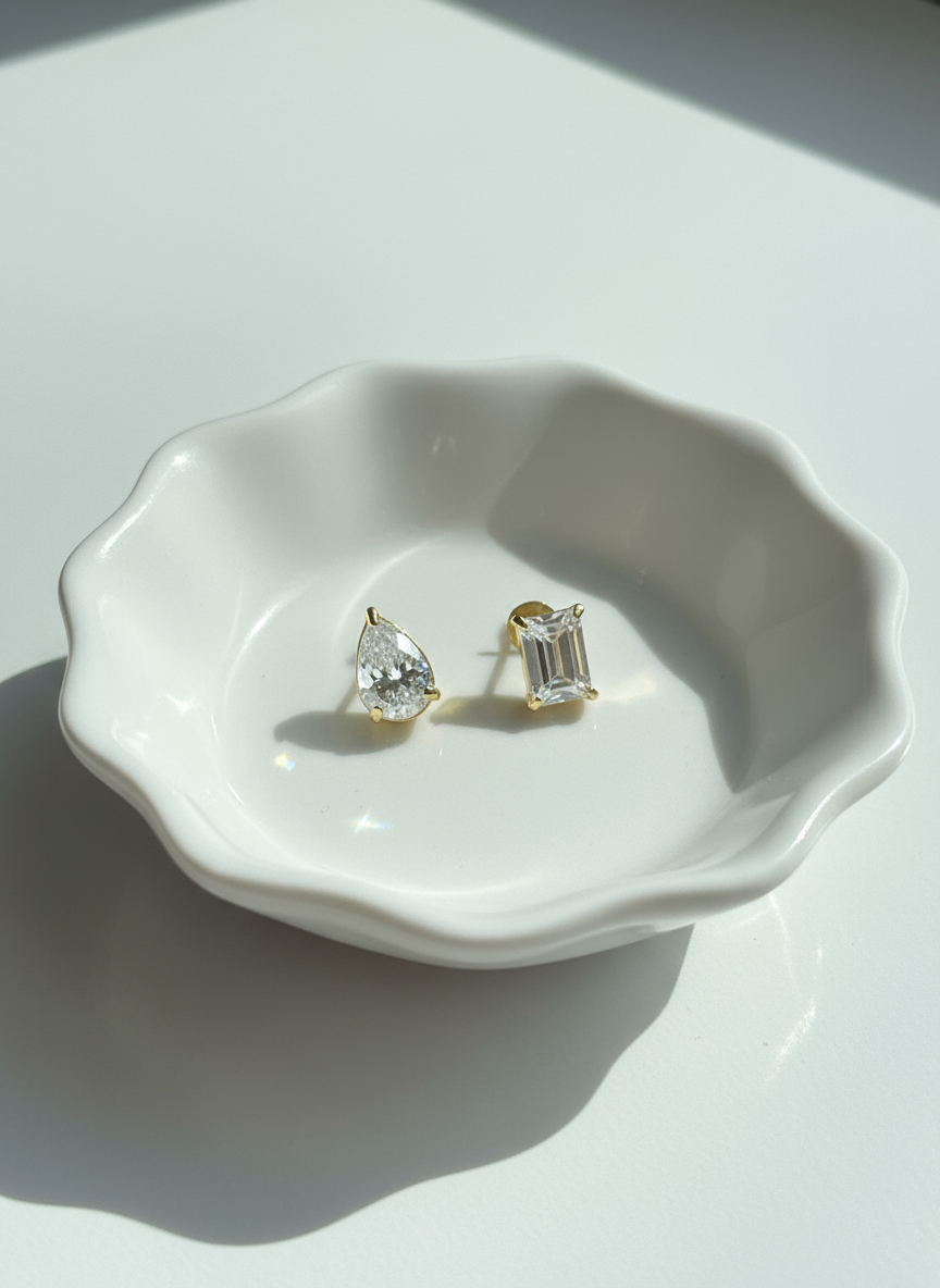 Pair of earrings on a white ceramic dish