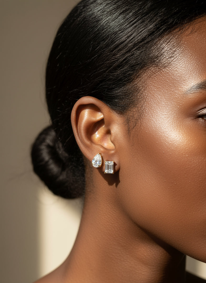 Close-up of a woman wearing diamond earrings with a neutral background